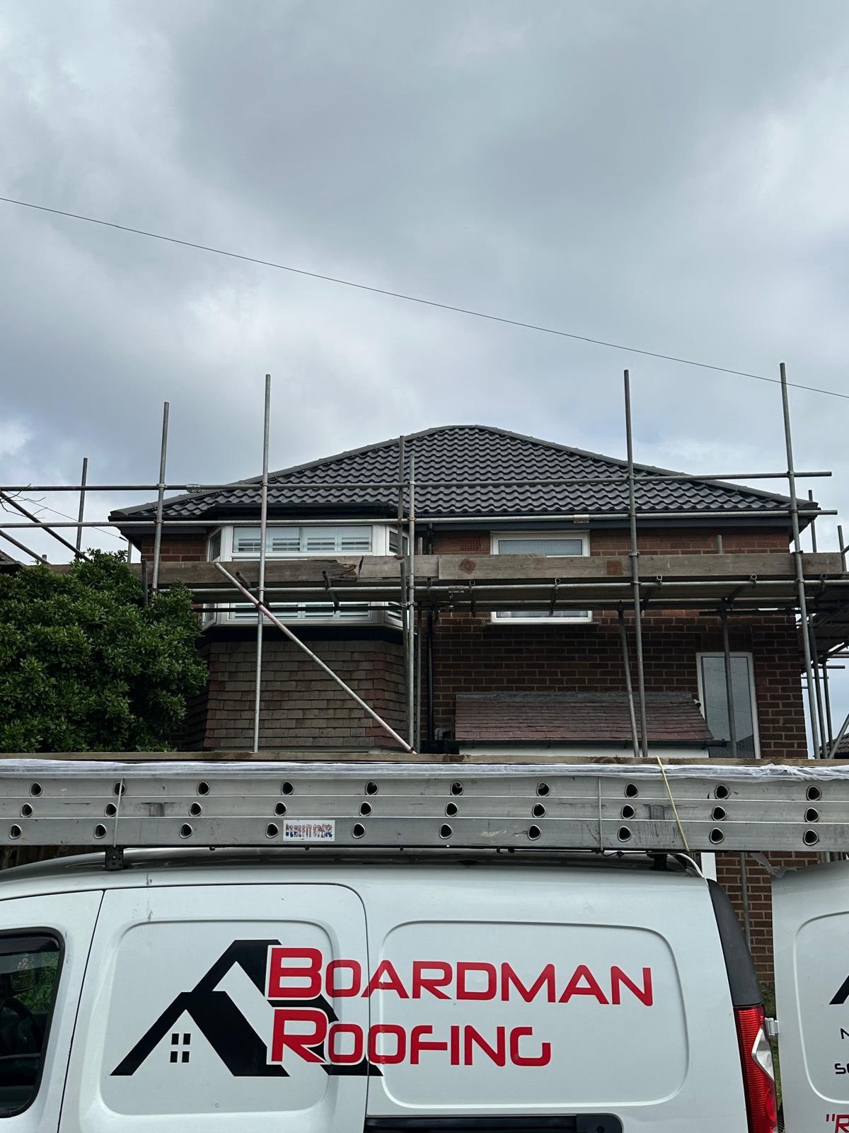 Pitched roof, scaffolding and a Boardman Roofing van