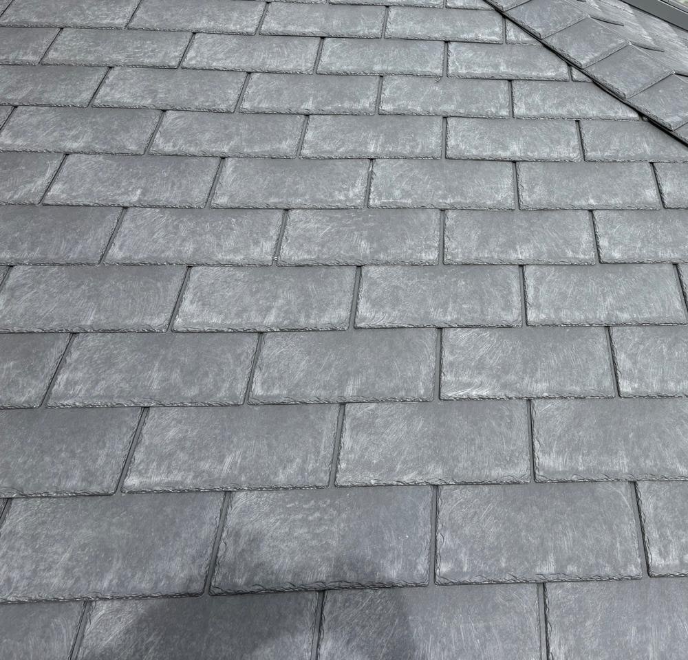 A close run of new grey slates meeting a hip